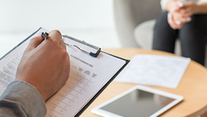 Doctor with patient sitting filling out form