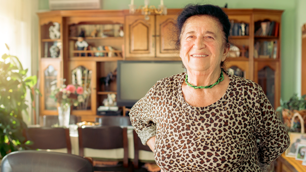 An older woman stands after a period of sitting.